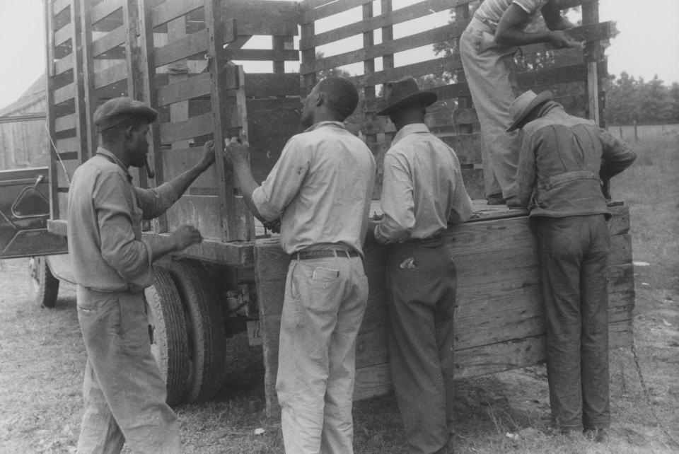 Migrant farmers prepare a truck for travel to Onley, Va., in July 1940, in a photo from the New York Public Library.