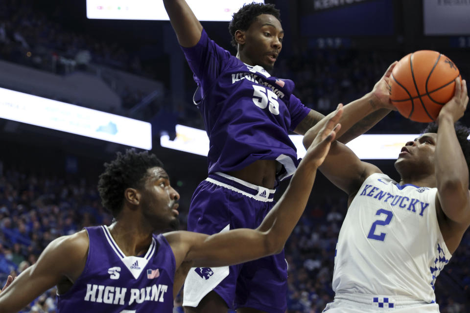 Kentucky's Sahvir Wheeler (2) shoots while pressured by High Point's Zack Austin (55) and Bryant Randleman (5) during the first half of an NCAA college basketball game in Lexington, Ky., Friday, Dec. 31, 2021. (AP Photo/James Crisp)