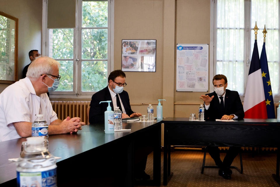 French President Emmanuel Macron, right, chairs a meeting with the medical staff of the Rene Dubos hospital center, in Pontoise, outside Paris, Friday Oct. 23, 2020. French Prime Minister Jean Castex said Thursday a vast extension of the nightly curfew that is intended to curb the spiraling spread of the coronavirus, saying "the second wave is here." The curfew imposed in eight regions of France last week, including Paris and its suburbs, is being extended to 38 more regions and Polynesia, (Photo by Ludovic Marin, Pool via AP)