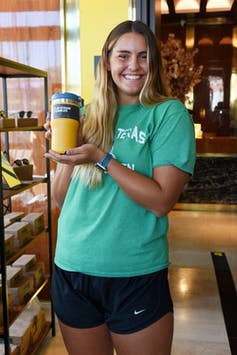 Young woman poses with a coffee tumbler