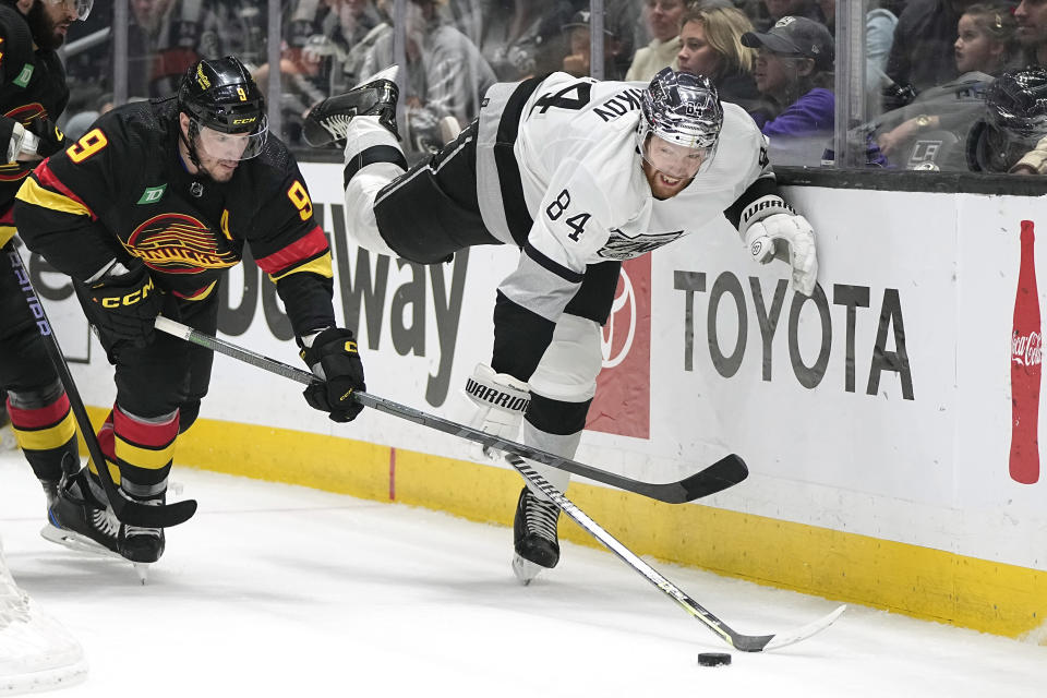 Vancouver Canucks center J.T. Miller, left, and Los Angeles Kings defenseman Vladislav Gavrikov vie for the puck during the first period of an NHL hockey game Monday, April 10, 2023, in Los Angeles. (AP Photo/Mark J. Terrill)