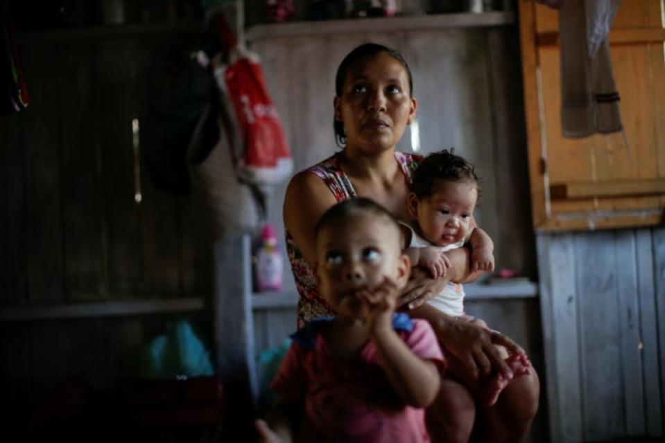 Maria de Jesus, de 36 años y en la imagen con sus dos hijos en la comunidad de Galileia, recibe la noticia por parte de los sanitarios de que ha dado positivo por coronavirus. (Foto: Uesley Marcelino / Reuters).