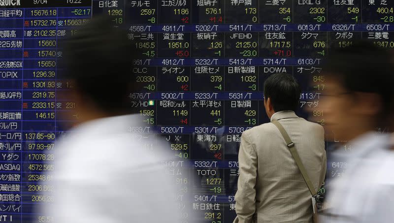 A man looks at an electronic stock quotation board outside a brokerage in Tokyo September 4, 2014. REUTERS/Issei Kato