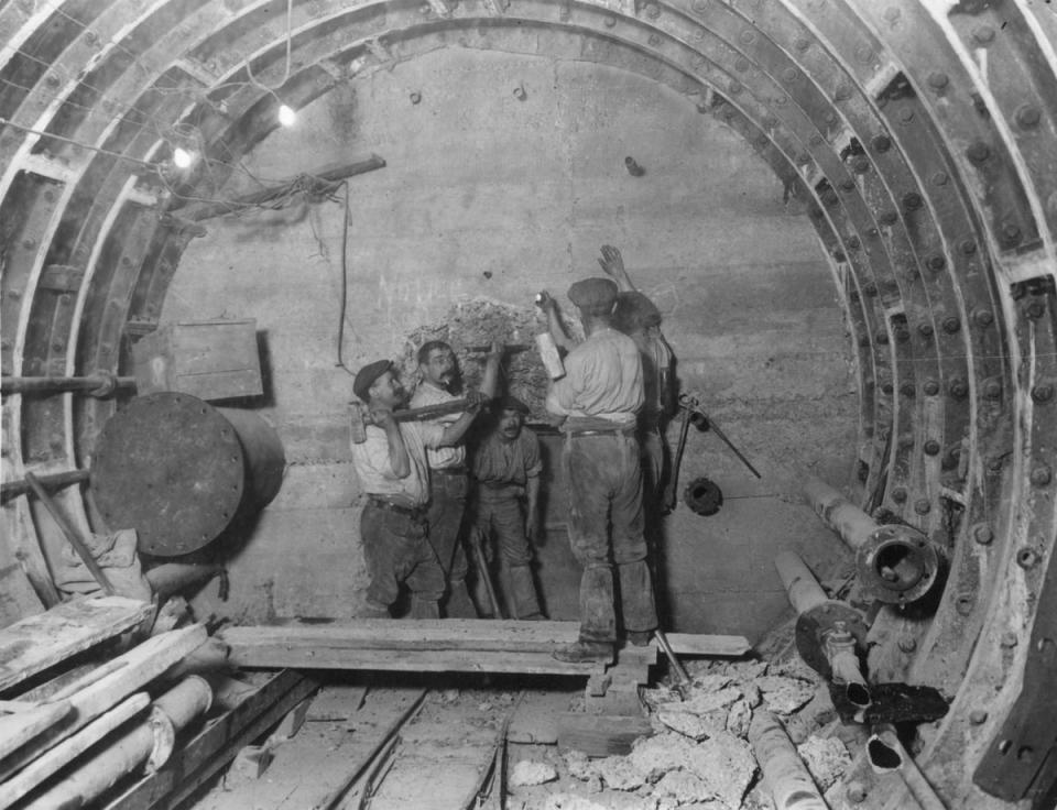 circa 1912: Workmen removing a concrete wall during construction of the Central line extension to Bank, on London's Underground Rail network (Getty Images)