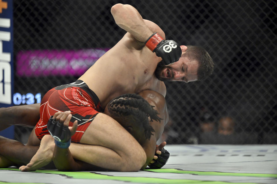 Mateusz Gamrot, top, punches Jalin Turner during a UFC 285 mixed martial arts lightweight bout Saturday, March 4, 2023, in Las Vegas. (AP Photo/David Becker) ORG XMIT: NVDB109