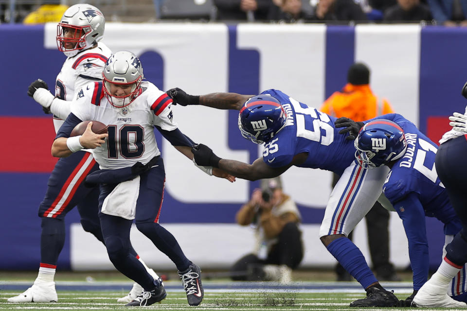 New York Giants linebacker Jihad Ward (55) grabs New England Patriots quarterback Mac Jones (10) during the second quarter of an NFL football game, Sunday, Nov. 26, 2023, in East Rutherford, N.J. (AP Photo/Adam Hunger)