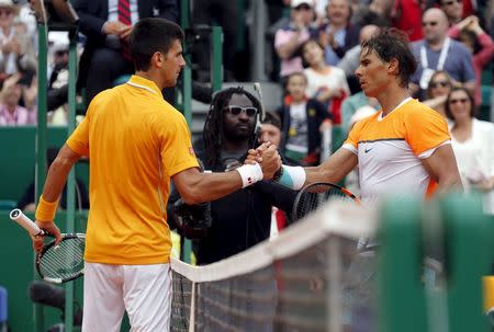 Novak Djokovic of Serbia (L) shakes hands with Rafael Nadal of Spain after their semi-final match at the Monte Carlo Masters in Monaco April 18, 2015. REUTERS/Jean-Paul Pelissier