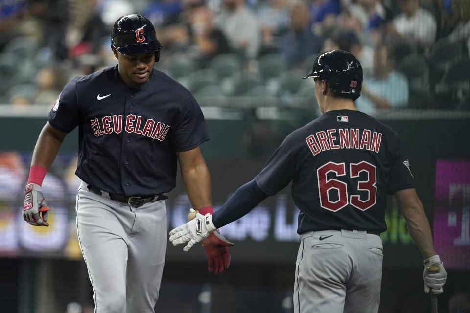 Oscar Gonzalez, left, and Will Brennan (63) celebrate after Gonzalez hit a solo home run in the fifth inning of a baseball game against the Texas Rangers in Arlington, Texas, Saturday, Sept. 24, 2022. (AP Photo/Tony Gutierrez)