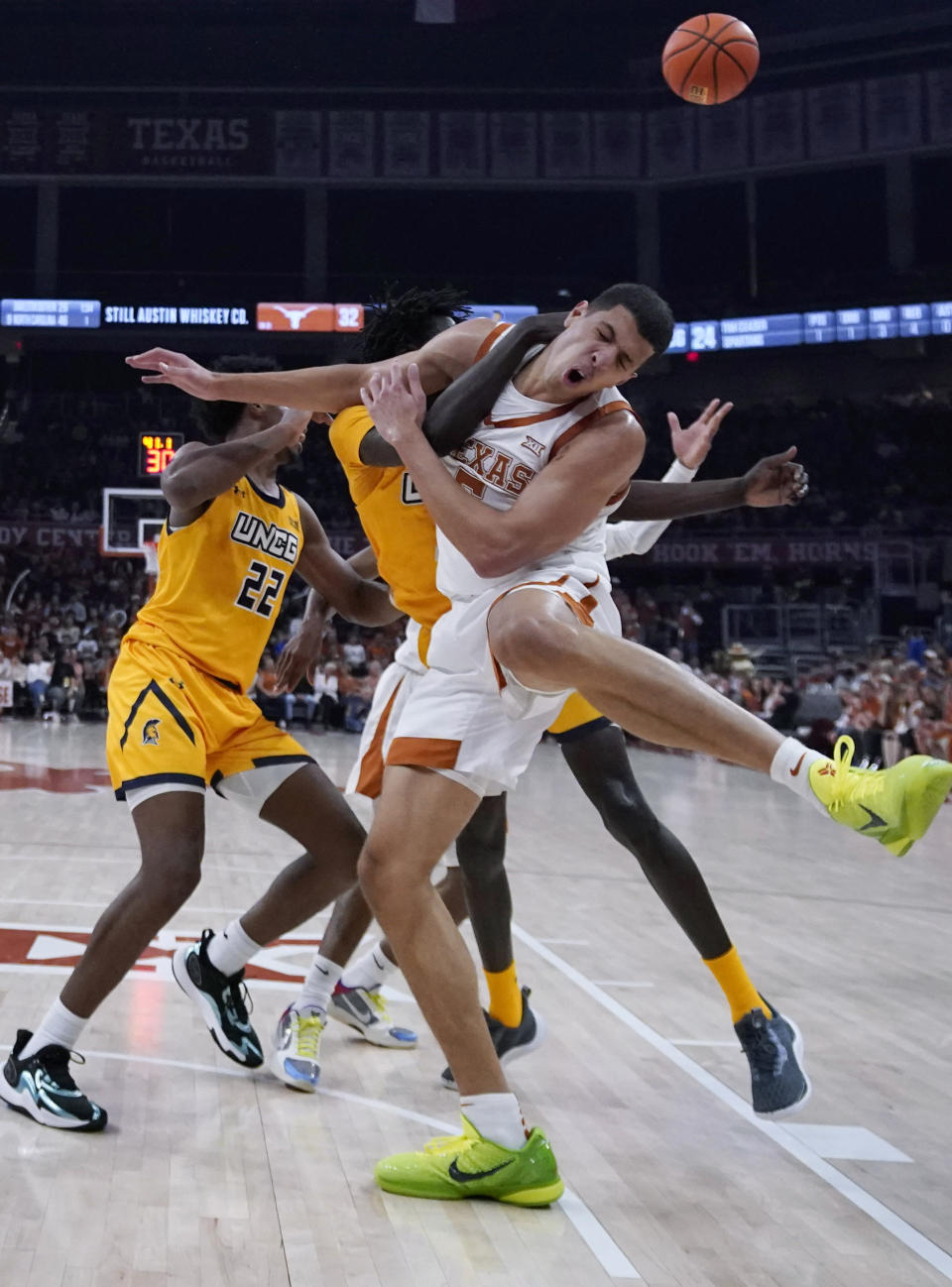 Texas forward Kadin Shedrick, front, and UNC Greensboro guard Muon Reath, center, compete for a rebound during the first half of an NCAA college basketball game in Austin, Texas, Friday, Dec. 29, 2023. (AP Photo/Eric Gay)