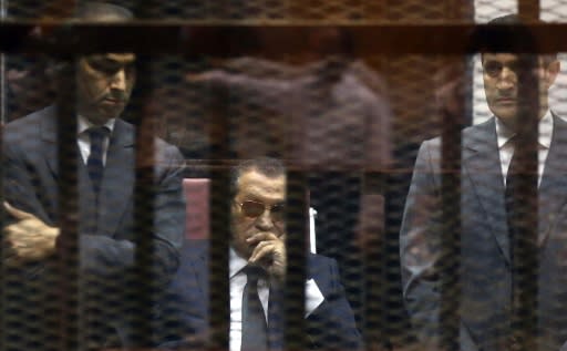 Hosni Mubarak sits in the defendant?s cage between his sons during a hearing in one of his trials following his ouster in 2011