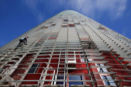 French climber Alain Robert, also known as "The French Spiderman", scales the 38-story skyscraper Torre Agbar in Barcelona, Spain, November 25, 2016. REUTERS/Albert Gea