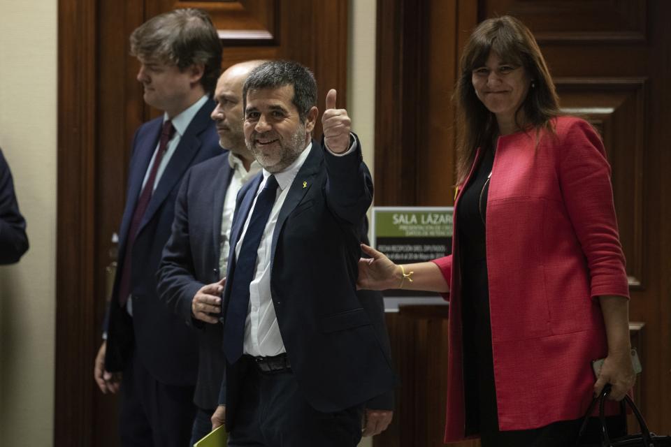Catalan politician Jordi Sanchez gestures a thumbs up to the media after collecting his credential at the Spanish parliament in Madrid, Spain, Monday, May 20, 2019. Five separatist leaders on trial for Catalonia's 2017 secession attempt who were elected to the Spanish Parliament in April 28 elections have been escorted by police to pick up their official credentials. The five, along with other defendants, are being held in pre-trial jail. They face several years in prison if found guilty of rebellion. (AP Photo/Bernat Armangue)