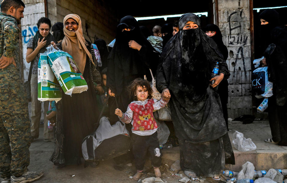 <p>Syrian women and children gather on the western front after fleeing the center of Raqqa on Oct.12, 2017. (Photo: Bulent Kilic/AFP/Getty Images) </p>