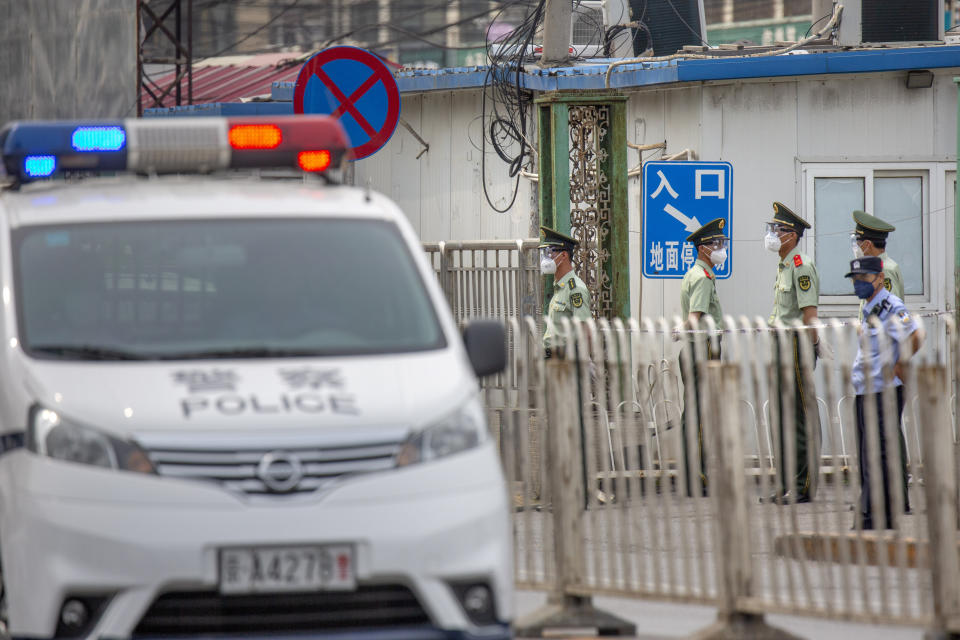 Paramilitary police stand guard on a street near the Xinfadi wholesale food market district in Beijing, Saturday, June 13, 2020. Beijing closed the city's largest wholesale food market Saturday after the discovery of seven cases of the new coronavirus in the previous two days. (AP Photo/Mark Schiefelbein)