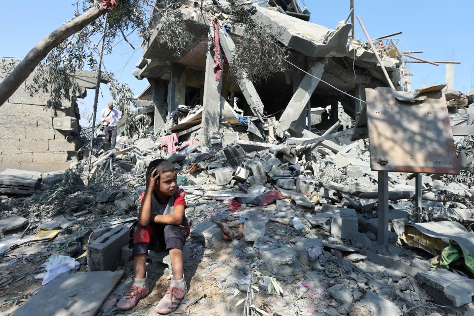 A child sits amid the rubble of a house destroyed by an Israeli strike in the Nusairat refugee camp, in the central Gaza Strip on Tuesday.