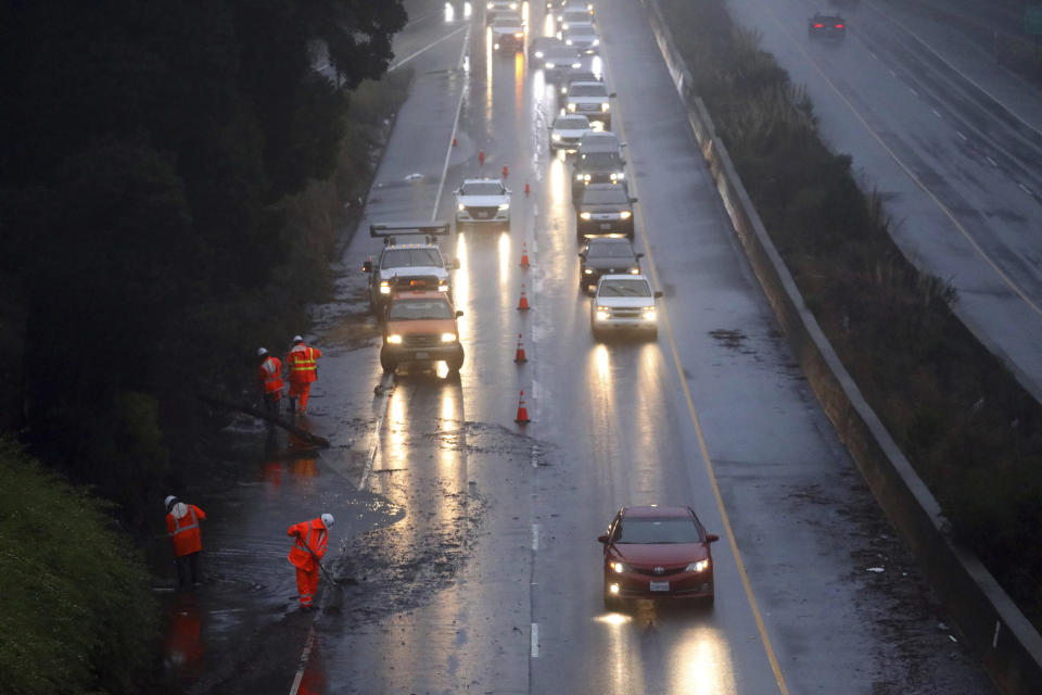 A Caltrans crew works to clear a flooded portion of northbound Highway 13 on Tuesday, Dec. 27, 2022, in Oakland, Calif. Rain is expected across the Bay Area this week. (Aric Crabb/Bay Area News Group via AP)