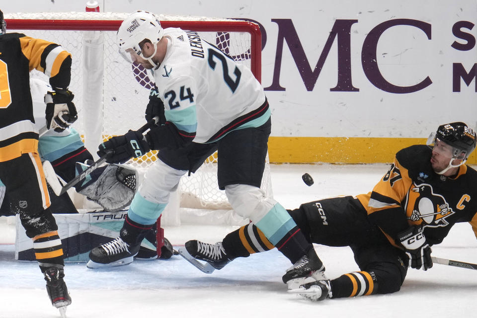 Pittsburgh Penguins' Sidney Crosby (87) is defended by Seattle Kraken's Jamie Oleksiak (24) during the first period of an NHL hockey game in Pittsburgh, Monday, Jan. 15, 2024. (AP Photo/Gene J. Puskar)