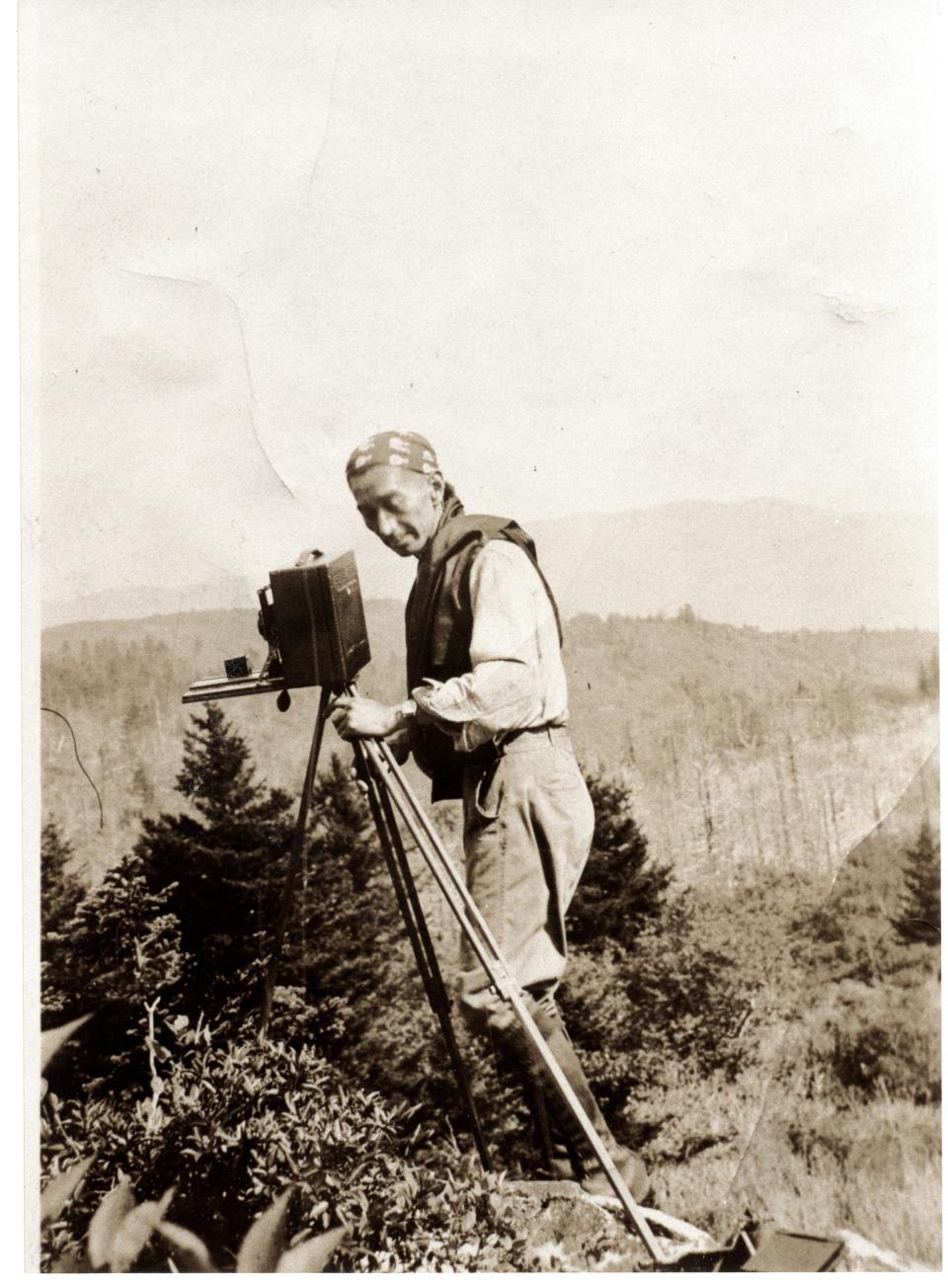 Dressed in his typical attire, George Masa sets up for a shot at Shining Rock in 1931.