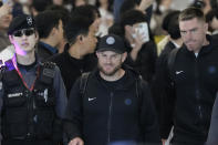 Los Angeles Dodgers' Max Muncy, center, and Freddie Freeman, right, walk with a security official during the baseball team's arrival at Incheon International Airport, Friday, March 15, 2024, in Incheon, South Korea, ahead of the team's baseball series against the San Diego Padres. (AP Photo/Ahn Young-joon)