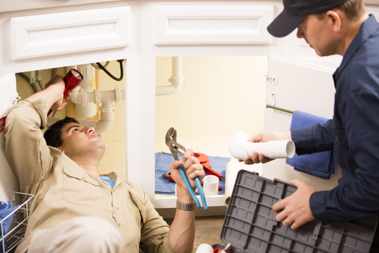 two plumbers fixing sink