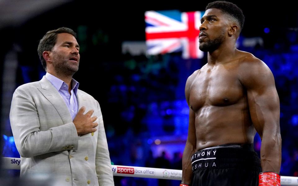 Anthony Joshua (right) and boxing promoter Eddie Hearn during the national anthem, - PA