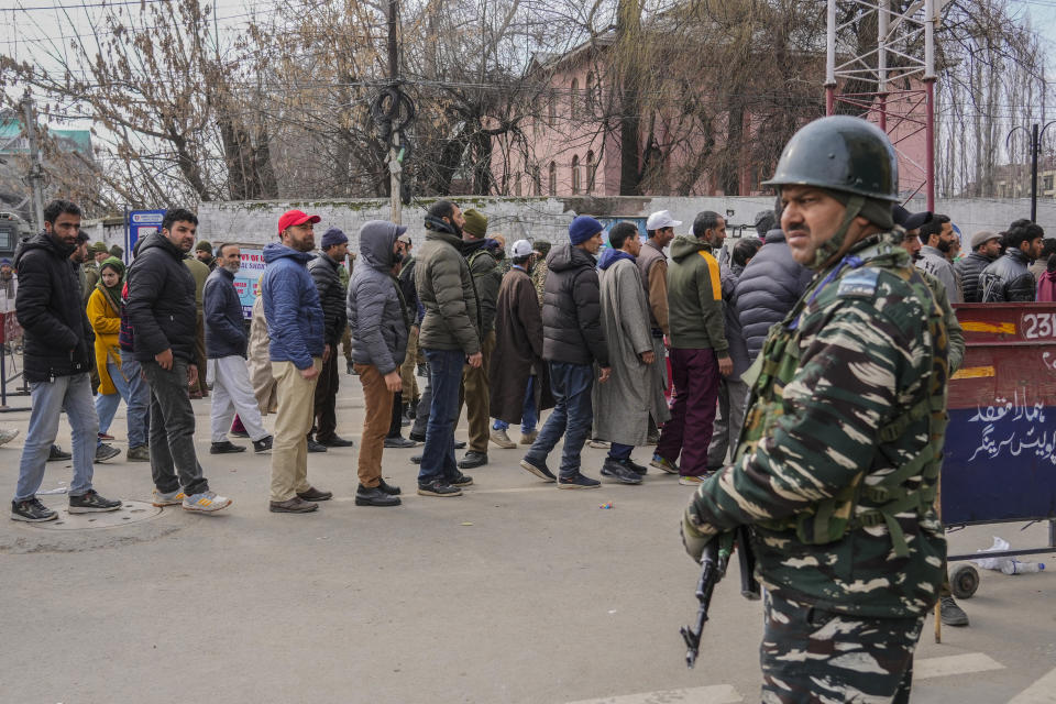 A paramilitary soldier guards as people queue up for security check outside a venue where Indian Prime Minister Narendra Modi is scheduled to address a public rally Srinagar, Indian controlled Kashmir, Thursday, March 7, 2024. Modi on Thursday is making his first official visit to Kashmir’s main city since New Delhi stripped the disputed region’s semi-autonomy and took direct control of it in 2019. (AP Photo/Mukhtar Khan)