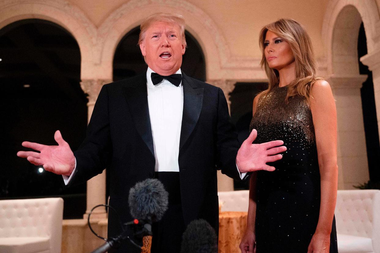 In this file photo taken on December 31, 2019, US President Donald Trump and First Lady Melania Trump speak to the press outside the grand ballroom as they arrive for a New Year's celebration at Mar-a-Lago in Palm Beach, Florida. - Trump's re-election team on January 2, 2020, revealed that he sits atop a staggering campaign war chest, underlining the scale of the challenge facing the US president's Democratic rivals at the start of an election year. In the fourth quarter of 2019, even as Trump was mired in a political scandal that resulted in his impeachment by the House of Representatives, he came out on top, raising a staggering $46 million. (Photo by JIM WATSON / AFP) (Photo by JIM WATSON/AFP via Getty Images) (AFP via Getty Images)