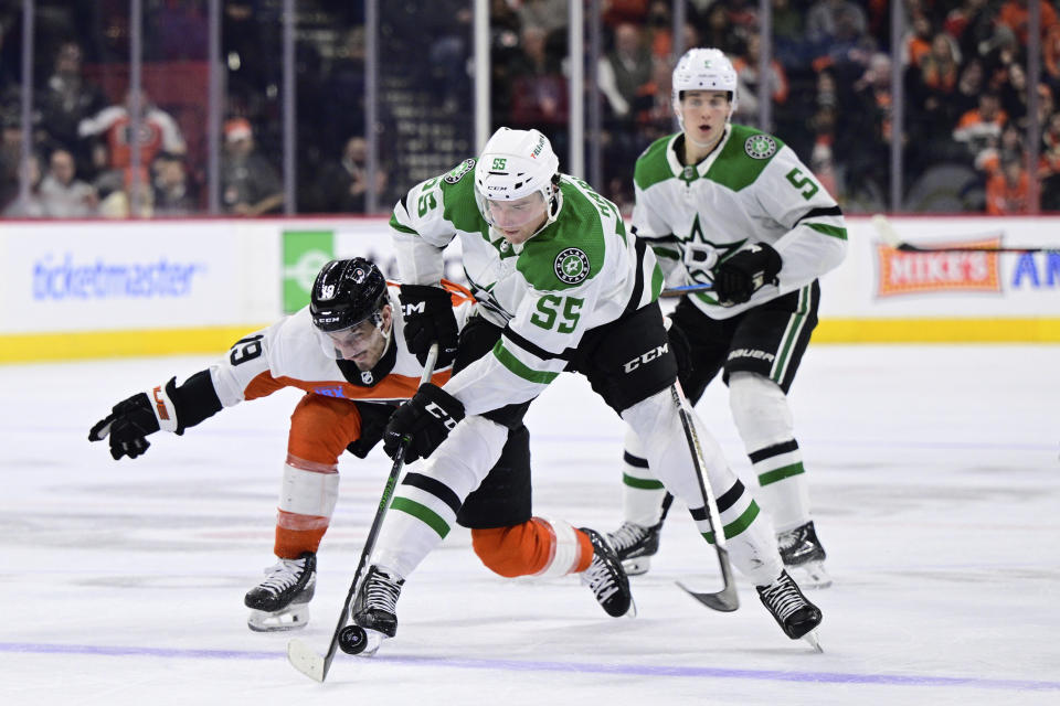 Dallas Stars' Thomas Harley (55) keeps the puck from Philadelphia Flyers' Garnet Hathaway (19) during the second period of an NHL hockey game Thursday, Jan. 18, 2024, in Philadelphia. (AP Photo/Derik Hamilton)