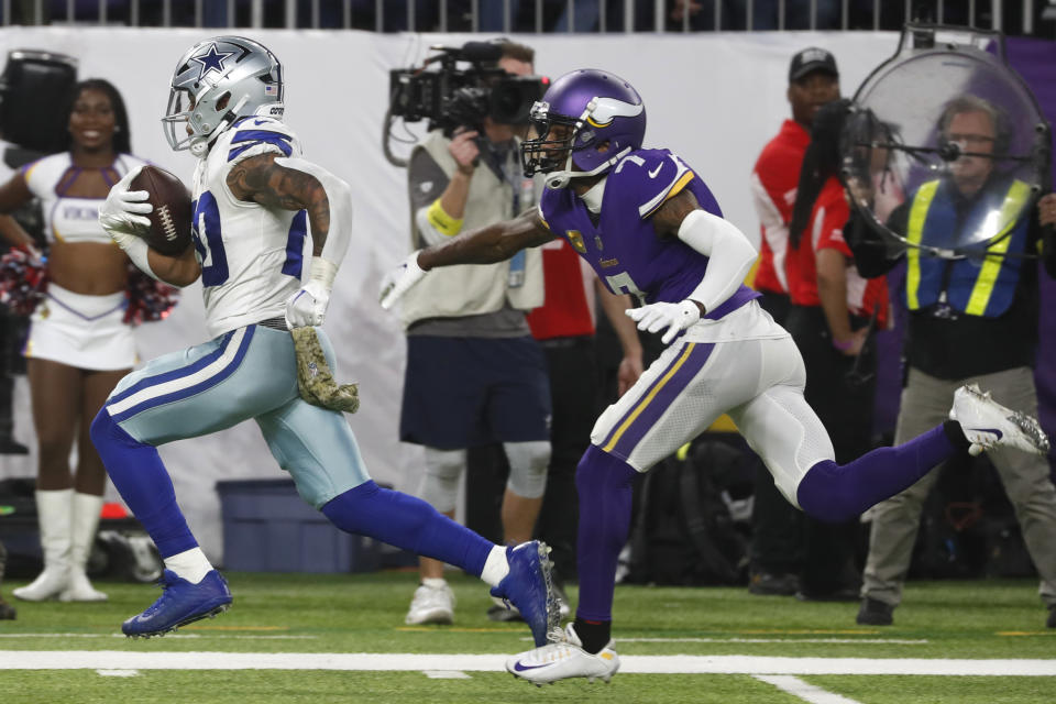 Dallas Cowboys running back Tony Pollard (20) runs from Minnesota Vikings cornerback Patrick Peterson (7) during a 30-yard touchdown reception in the first half of an NFL football game, Sunday, Nov. 20, 2022, in Minneapolis. (AP Photo/Bruce Kluckhohn)