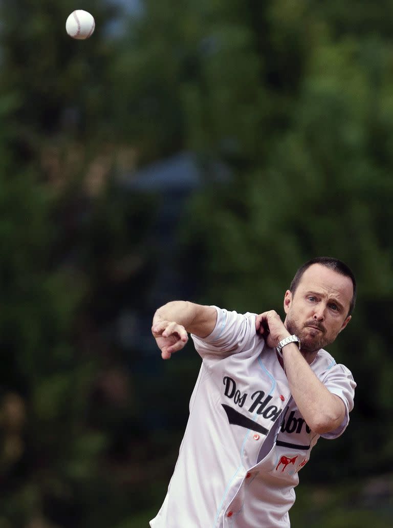 Aaron Paul lanza el primer lanzamiento a su compañero de reparto Bryan Cranston antes del comienzo del partido entre los Albuquerque Isotopes y Las Vegas Aviators 