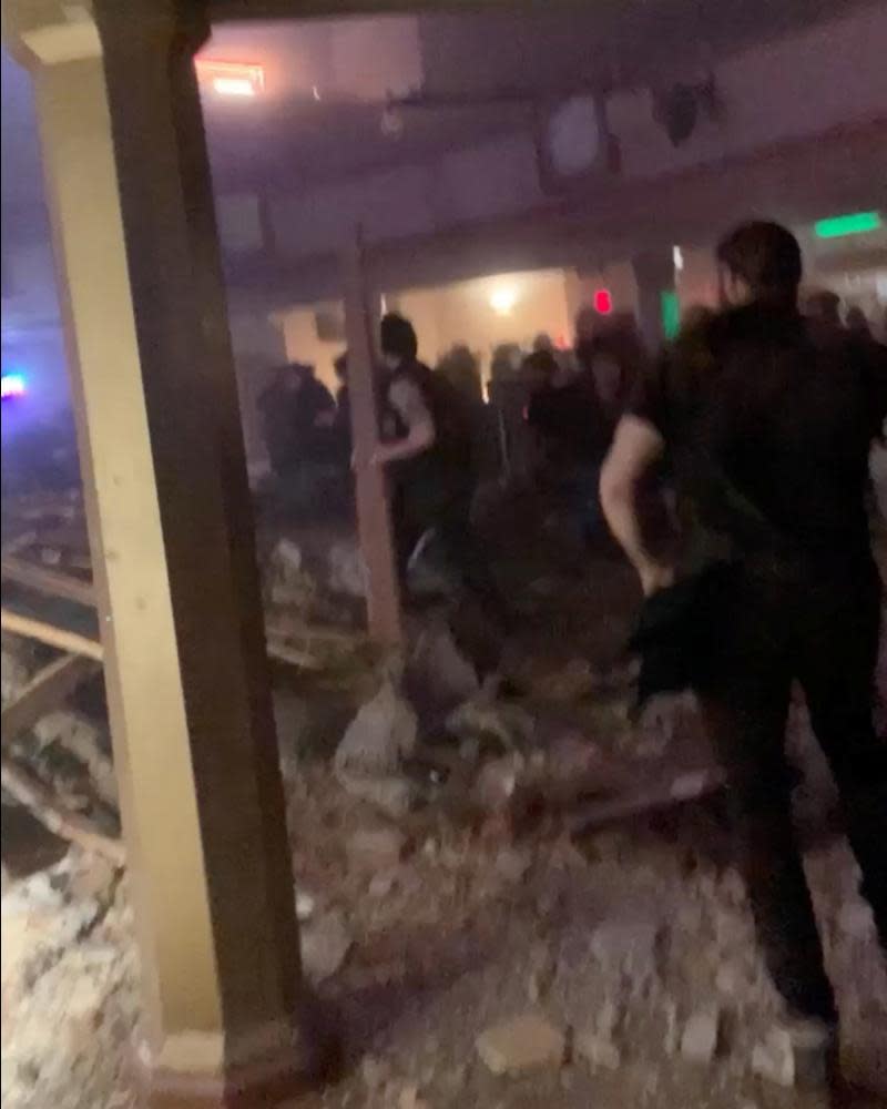 People sift through debris after the roof of the Apollo Theater in Belvidere collapsed.