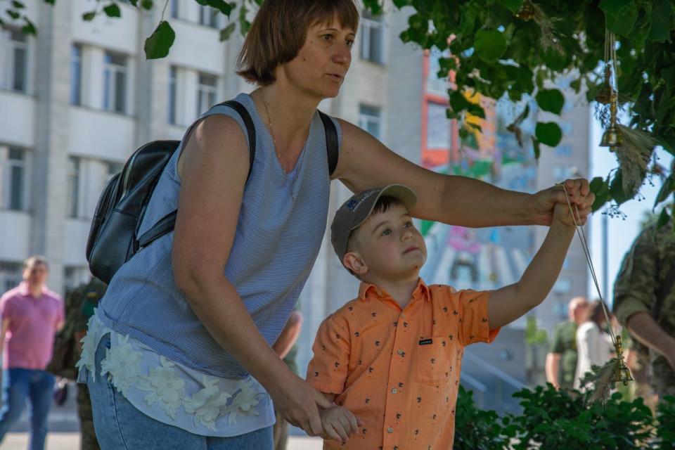 People hang bells on a tree, “symbolizing the voices of the killed children,” during a commemoration ceremony in Kyiv on June 4. (Kyiv City Military Administration/Telegram)