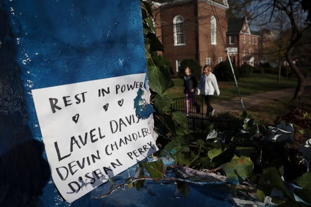 PHOTO: Students walk past a sign memorializing three University of Virginia football players killed during an overnight shooting at the university, Nov. 14, 2022, in Charlottesville, Va. (Win McNamee/Getty Images)