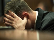 Oscar Pistorius, holds his head in his hands in the dock during cross examination of a witnesses in court in Pretoria, South Africa, Tuesday, March 18, 2014. Pistorius is on trial for the murder of his girlfriend Reeva Steenkamp on Valentine's Day, 2013. (AP Photo/Brendan Croft, Pool)