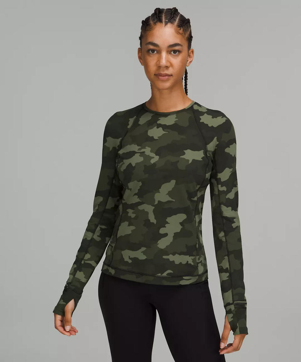 model wears green camo It&#39;s Rulu Run Long Sleeve Shirt. 