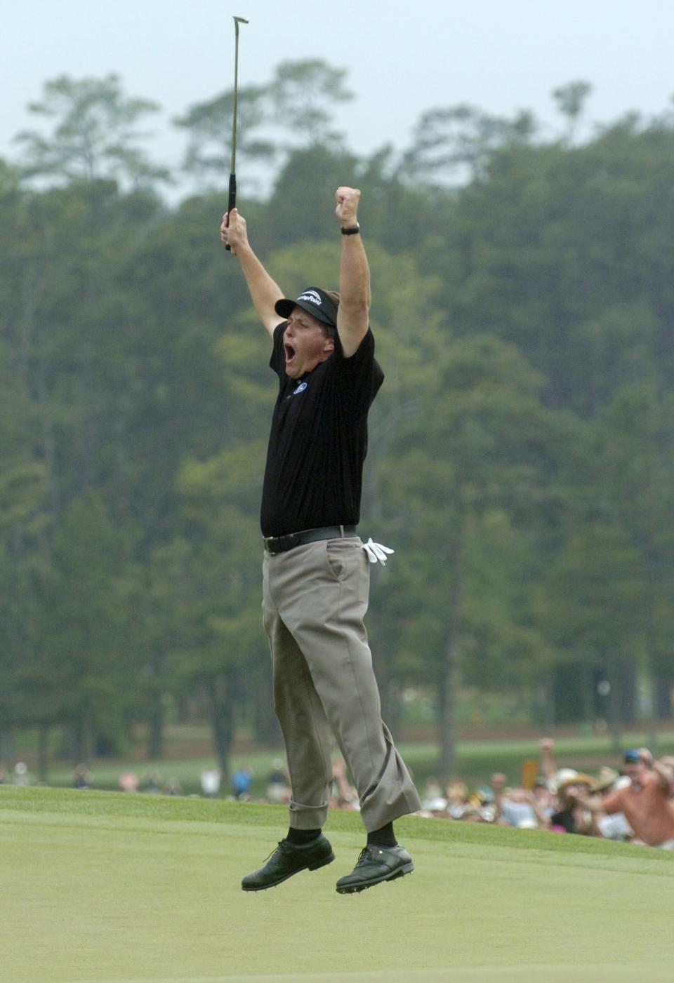 Phil Mickelson celebrates winning the 2004 Masters on the 18th green.