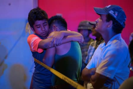 A man is comforted at a crime scene following a deadly attack at a bar by unknown assailants in Coatzacoalcos