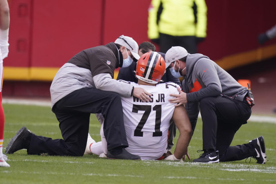 Cleveland Browns offensive tackle Jedrick Wills Jr. is helped off the field after getting injured during the first half of an NFL divisional round football game against the Kansas City Chiefs, Sunday, Jan. 17, 2021, in Kansas City. (AP Photo/Charlie Riedel)