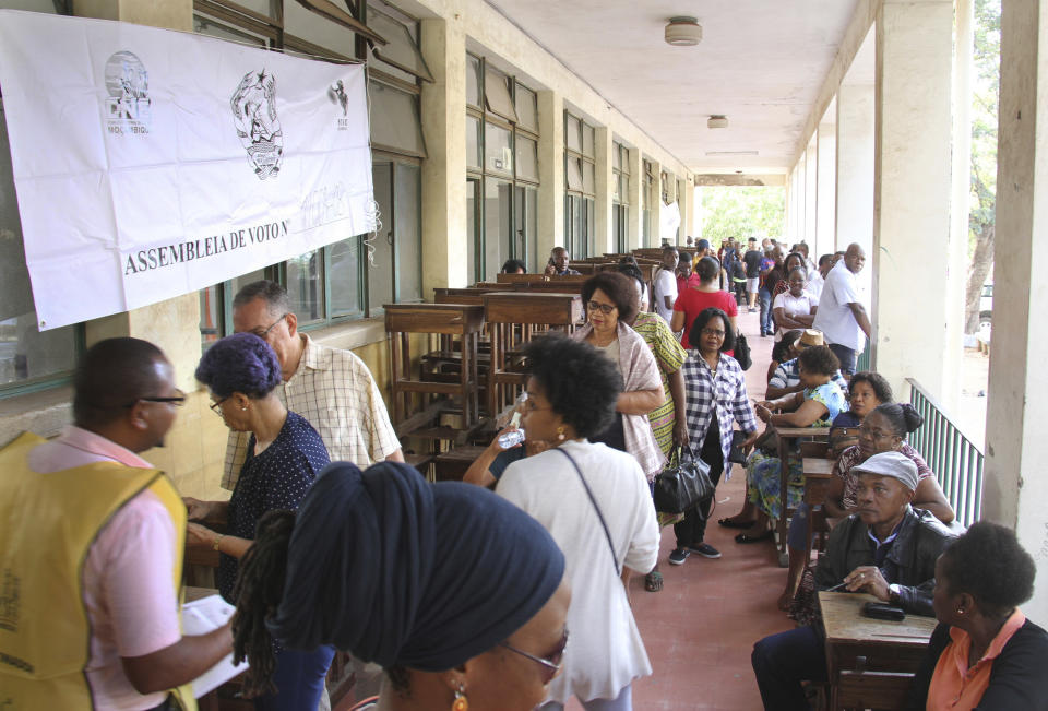 Voters queue to cast their votes in Maputo, Tuesday, Oct. 15, 2019, in the country's presidential, parliamentary and provincial elections. Polling stations opened across the country with 13 million voters registered to cast ballots in elections seen as key to consolidating peace in the southern African nation. (AP Photo/Ferhat Momade)