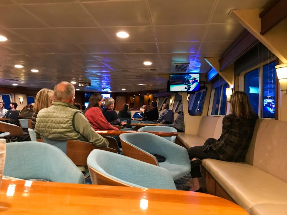 Fellow passengers and crew members gather in the lounge for an end-of-day recap.