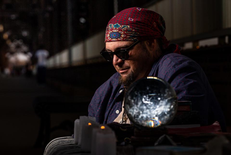 Fortune teller Steven Lafferty sits at his table on the Big Four Bridge in Louisville, Ky. Lafferty engages those who stop by with his experience as a mystic and his life as a fortune teller. Nov. 10, 2022