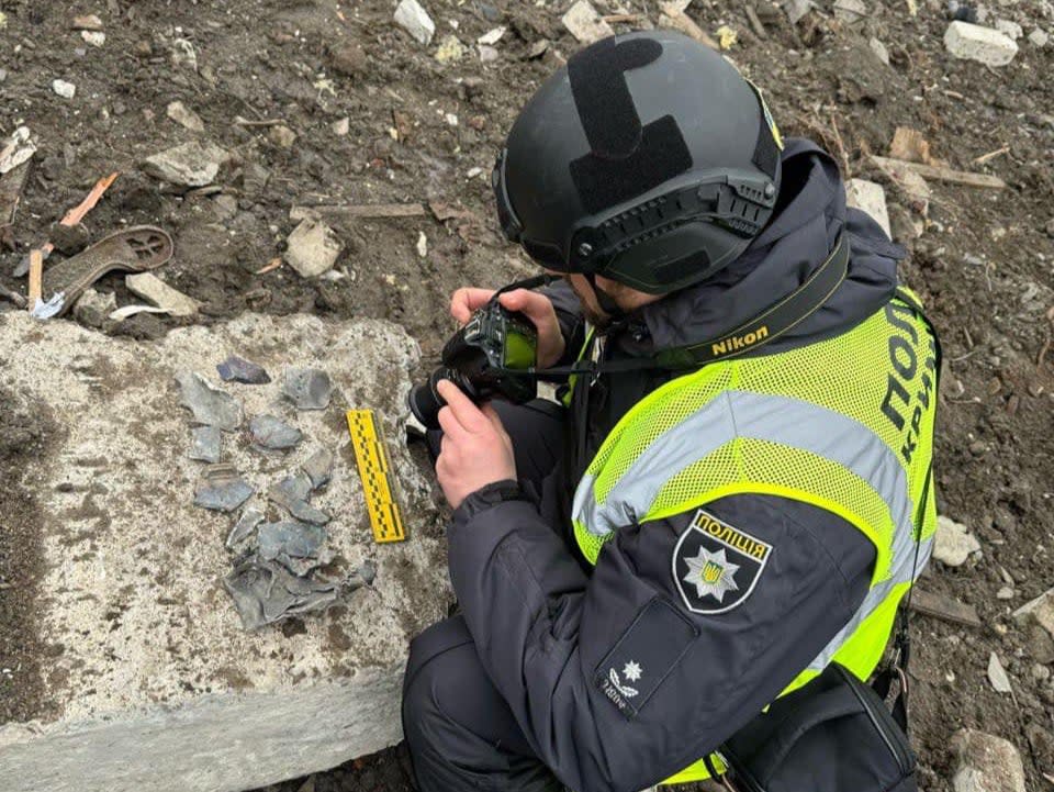 A Ukrainian police officer in Kharkiv takes pictures allegedly showing the debris of a North Korean missile (Serhiy Bolvinov / Facebook)