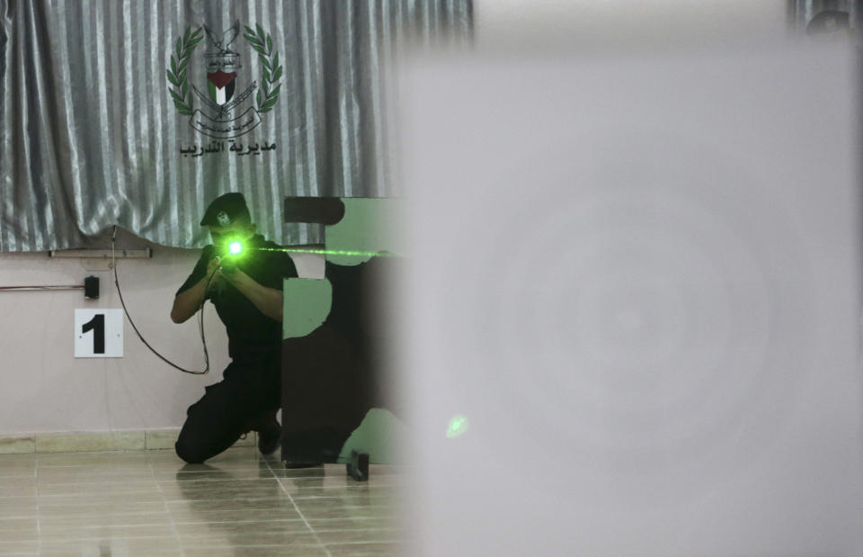 Palestinian security officer Muhmmad Debo, 22, practices with an electronically-modified AK-47 rifle at the headquarters of the security training department of the Hamas interior ministry in Gaza City, in the northern Gaza Strip on Thursday, April 10, 2014. The laser-fitted rifles are a money saver that eliminates the need to train with live ammunition, which is in short supply in Gaza. (AP Photo/Adel Hana)