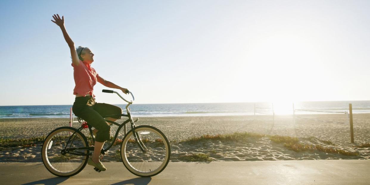 caucasian woman riding bicycle near beach, vitamin d