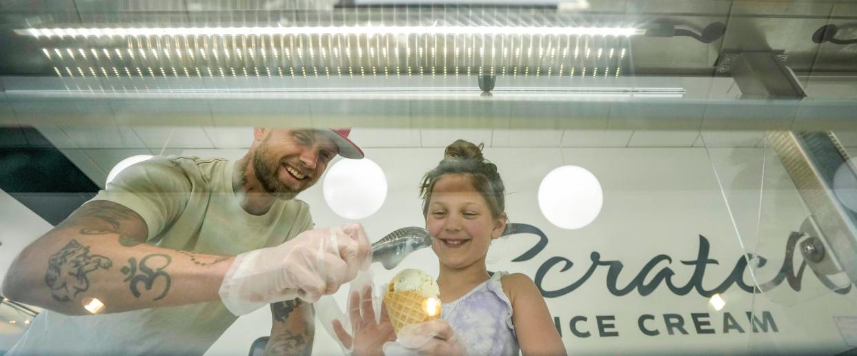 Ryan Povlick and his daughter Gianna share a moment while scooping ice cream on May 23, 2023 at Scratch Ice Cream in Brookfield. "My favorite part is having a business that my daughter enjoys coming to," Povlick said. Gianna comes and helps out around the shop after school. She wants to own a business when she grows up.