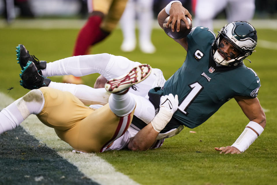 El quarterback Jalen Hurts de los Eagles de Filadelfia al ser derribado por Nick Bosa de los 49ers de San Francisco en el campeonato de la NFC, el domingo 29 de enero de 2023, en Filadelfia. (AP Foto/Seth Wenig)