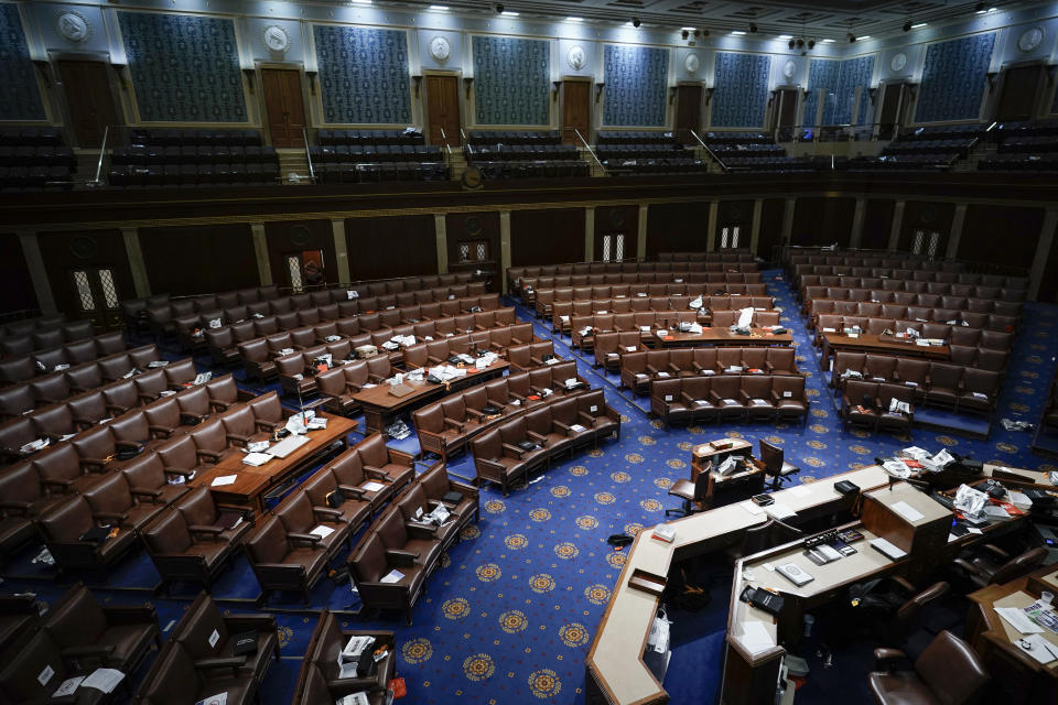 FILE - Papers and gas masks are left behind after House of Representatives members left the floor of the House chamber as rioters try to break into the chamber at the U.S. Capitol on Jan. 6, 2021, in Washington. (AP Photo/J. Scott Applewhite)