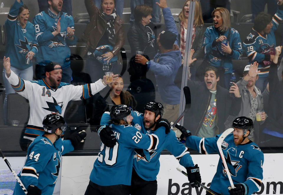 San Jose Sharks' Marc-Edouard Vlasic (44) and Marcus Sorensen (20) celebrate with teammate Joe Thornton, third from left, who scored his 400th career goal in the third period of an NHL hockey game against the Nashville Predators, in San Jose, Calif., Tuesday, Nov. 13, 2018. (AP Photo/Josie Lepe)