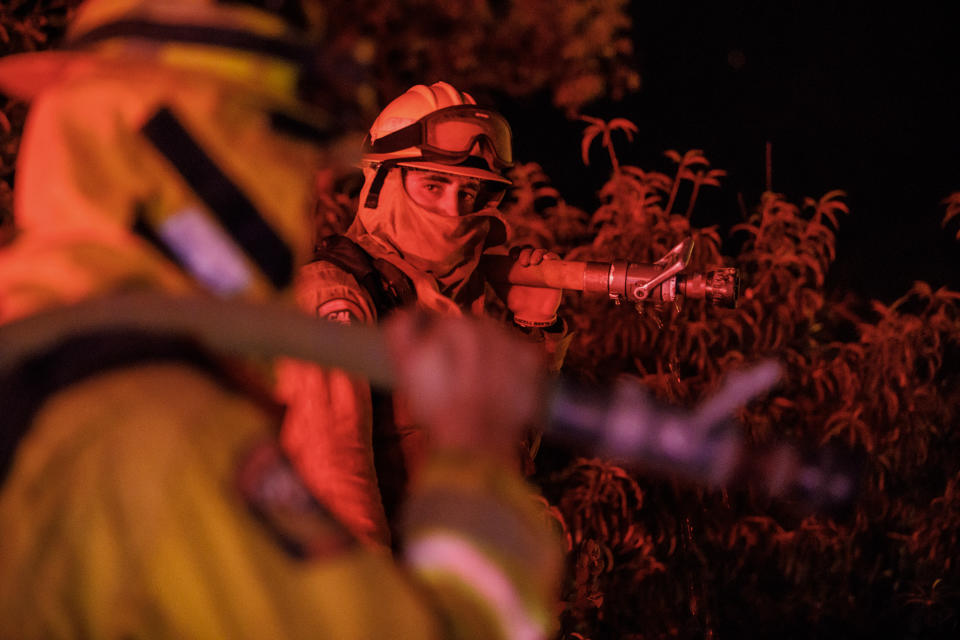 <p>Firefighters performing structure protection in the mountains above Lake Elsinore, Calif., on Aug. 10, 2018. (Photo: Marcus Yam/Los Angeles Times via Getty Images) </p>