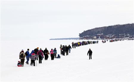 Sightseers trek across a frozen expanse of Lake Superior, the world's largest freshwater lake, to the sea caves of the Apostle Islands National Lakeshore near Cornucopia, Wisconsin February 15, 2014. REUTERS/Eric Miller